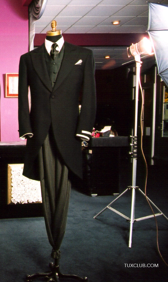 Black cutaway morning suit on a mannequin with a pink wall and studio lighting equipment in the background.