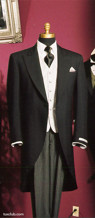Black cutaway morning suit with white shirt and black satin long dress tie on a mannequin against a red wall.