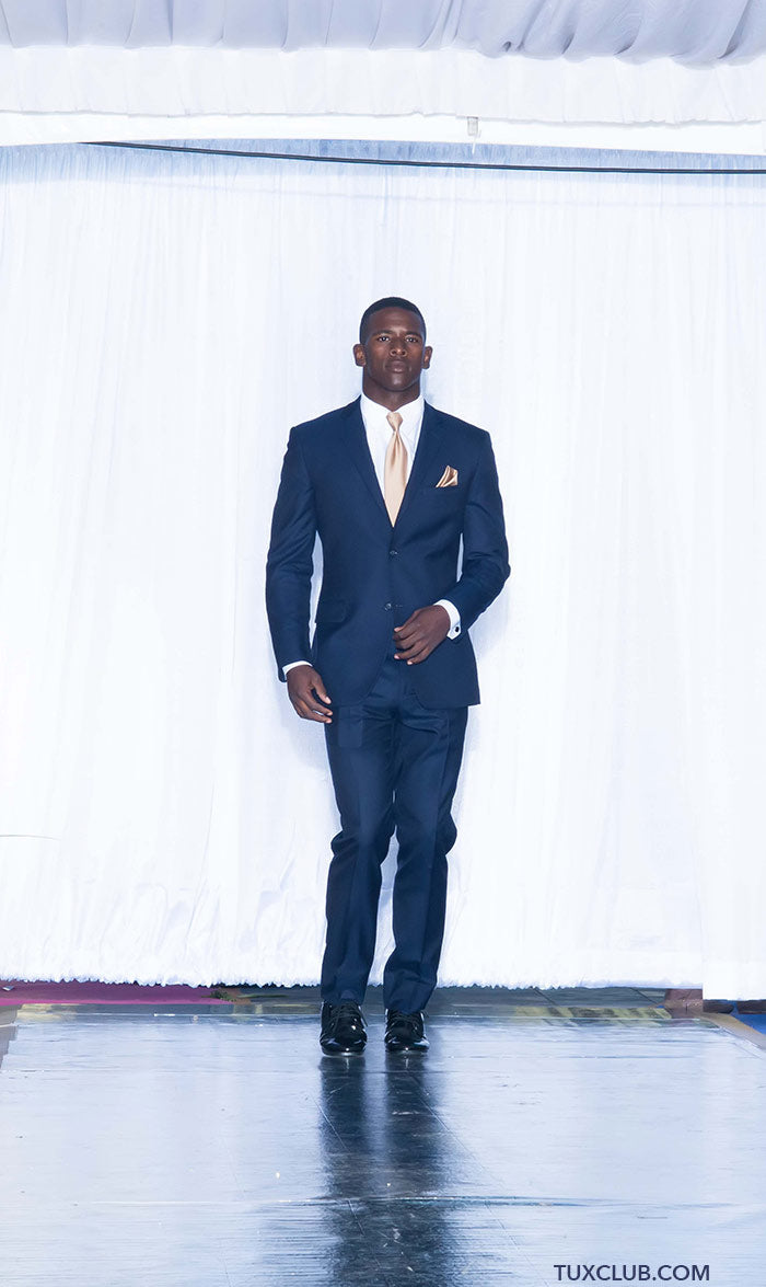 handsome black man wearing a navy blue slim-fit suit with a white shirt and tie on a white background