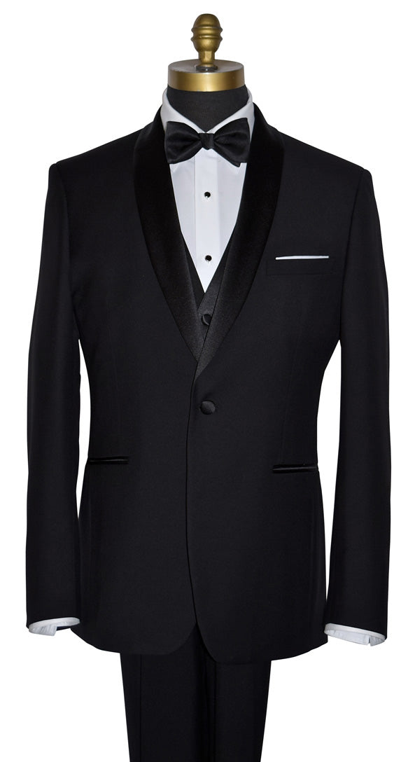 front view of Black one button shawl collar tuxedo by tuxclub, with white lay-down collar tuxedo shirt and black satin bowtie with a black vest and white pocket handkerchief. The tuxedo shirt has black onyx studs and cufflinks with silver trim. Photo taken at TUX CLUB in San Diego, California.