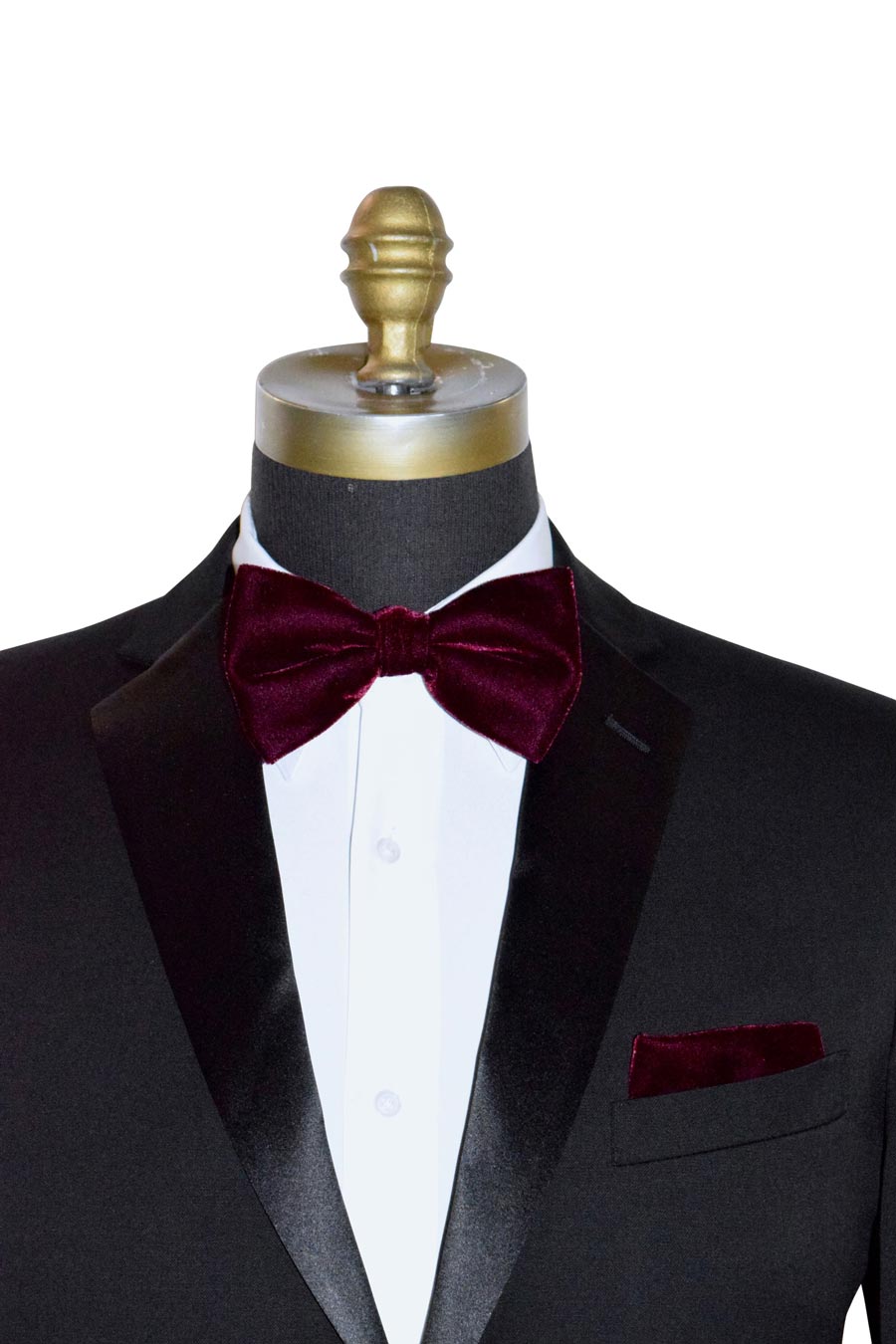 Black tuxedo with a burgundy velvet bow tie and pocket square on a mannequin against a white background