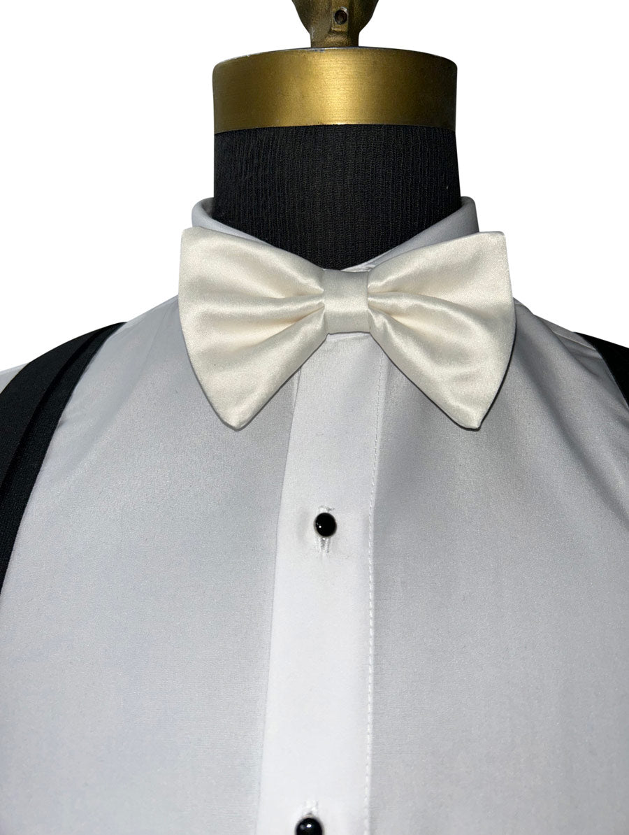 ivory satin bow tie on a mannequin wearing a white dress shirt with black suspenders