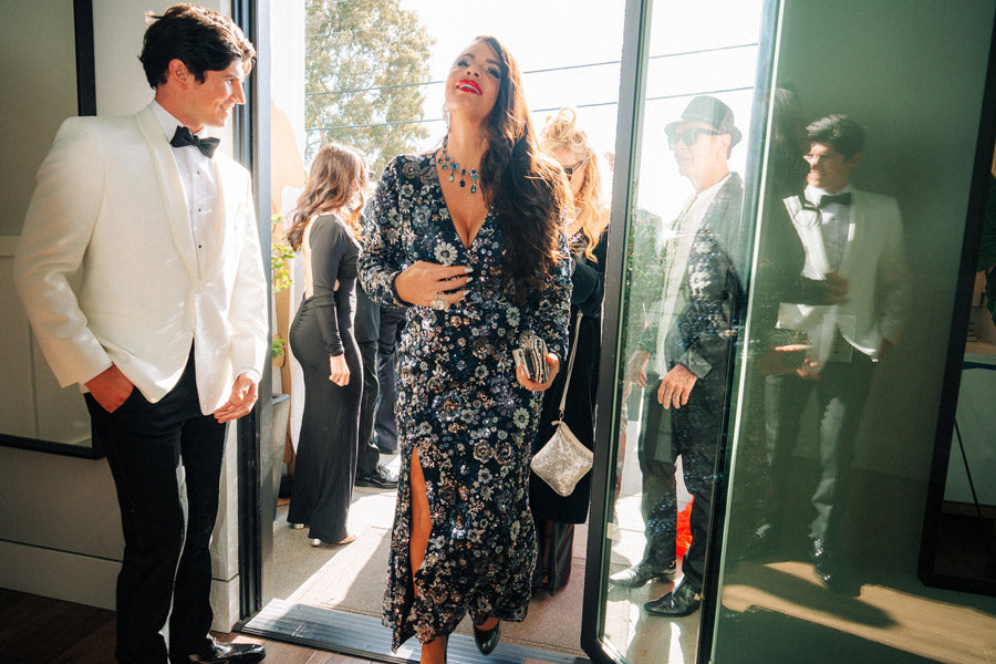 Model wearing an off-white tuxedo with a woman in a floral gown at the San Diego Film Festival private party in La Jolla, California.