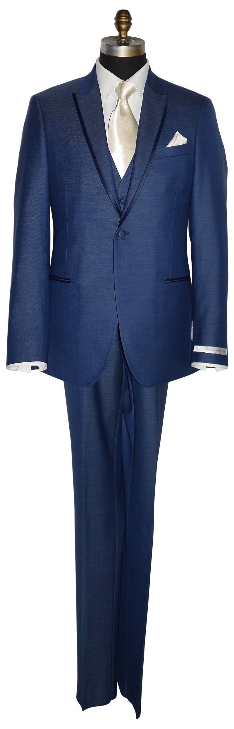 life-size mannequin wearing a new-blue three piece tuxedo with an ivory dress shirt with an ivory long necktie and ivory pocket handkerchief against a white background