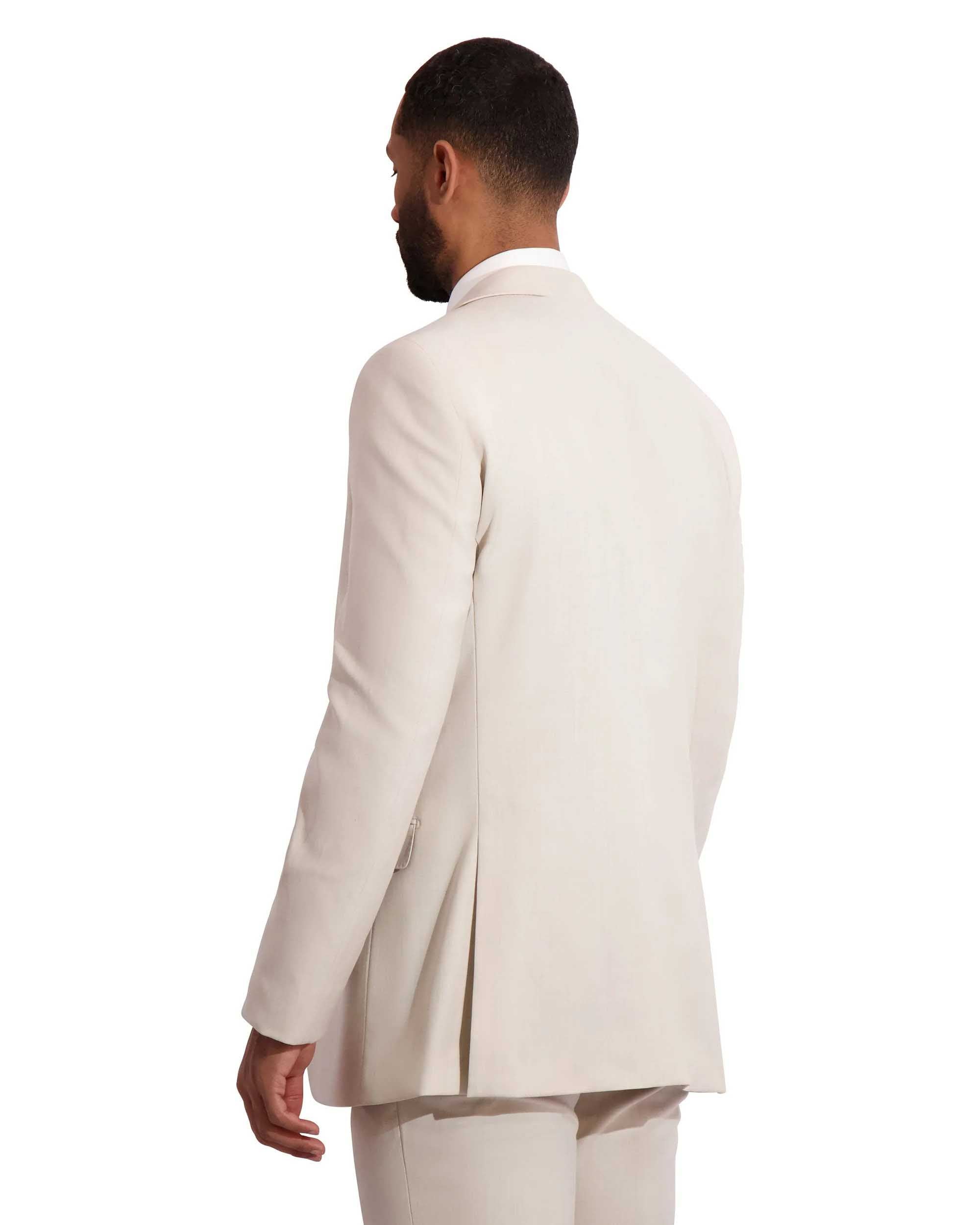Back View of hispanic model wearing a tan fitted wedding suit.
