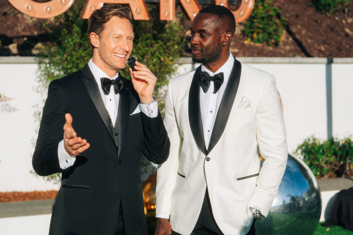 Master of ceremonies wearing peak lapel tuxedo with black vest and bowtie at a party
