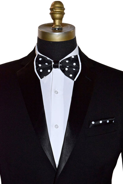 Black tuxedo with a white dress shirt and black bow tie with white polka-dots on a mannequin against a white background