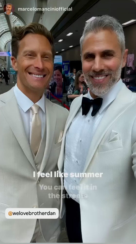 TUXCLUB model wearing a sim fit tan suit and tan vest with an ivory long dress tie while at a convention in San Diego.