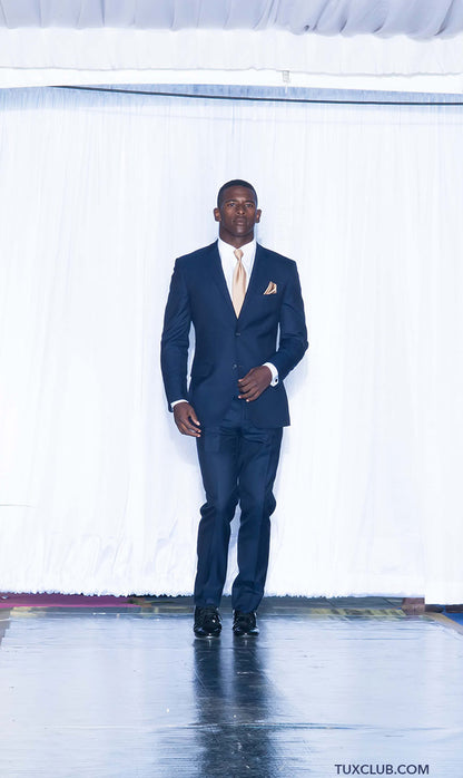 handsome black man wearing a navy blue slim-fit suit with a white shirt and tie on a white background