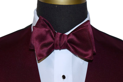 close-up front view Wine "tie-yourself" bow tie on a mannequin with a white shirt and black tuxedo jacket.