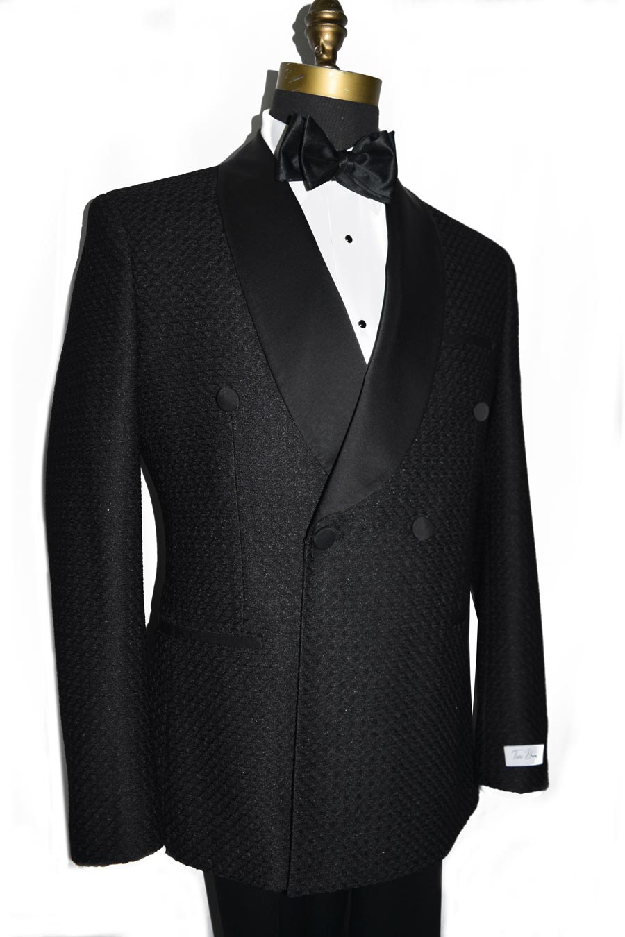 side view black double-breasted shawl collar tuxedo with a black bow tie against a white background 