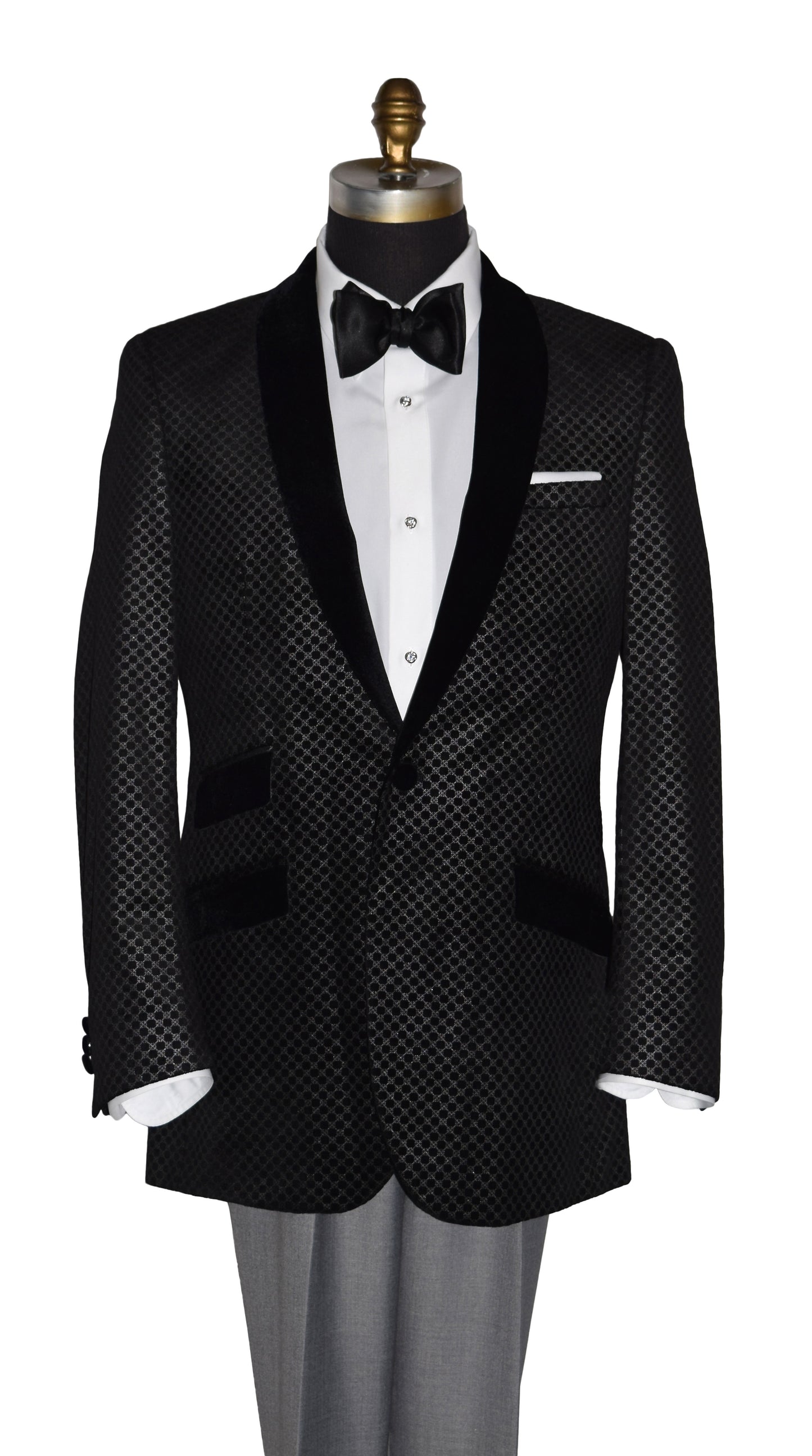Black velvet tuxedo with silver design with white shirt and black bow tie on a mannequin against a white background