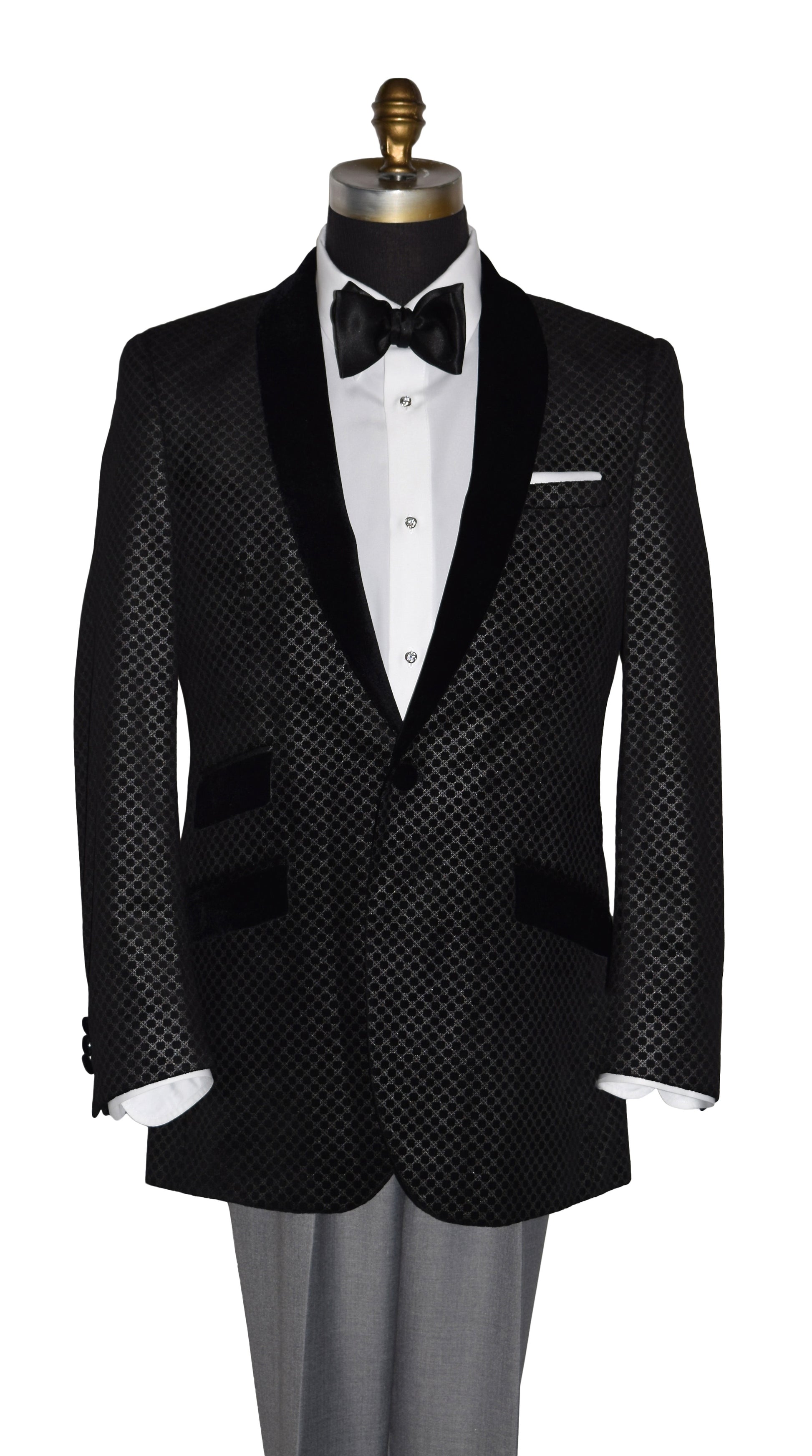 Black velvet tuxedo with silver design with white shirt and black bow tie on a mannequin against a white background