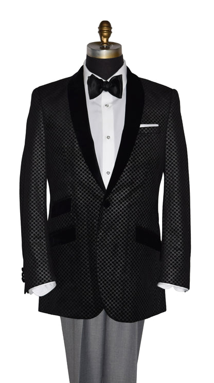 Black velvet tuxedo with silver design with white shirt and black bow tie on a mannequin against a white background