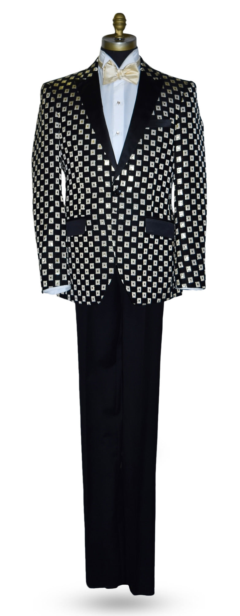 Black with ivory and gold squares pattern tuxedo jacket with a white shirt and gold bow tie on a mannequin against a white background.