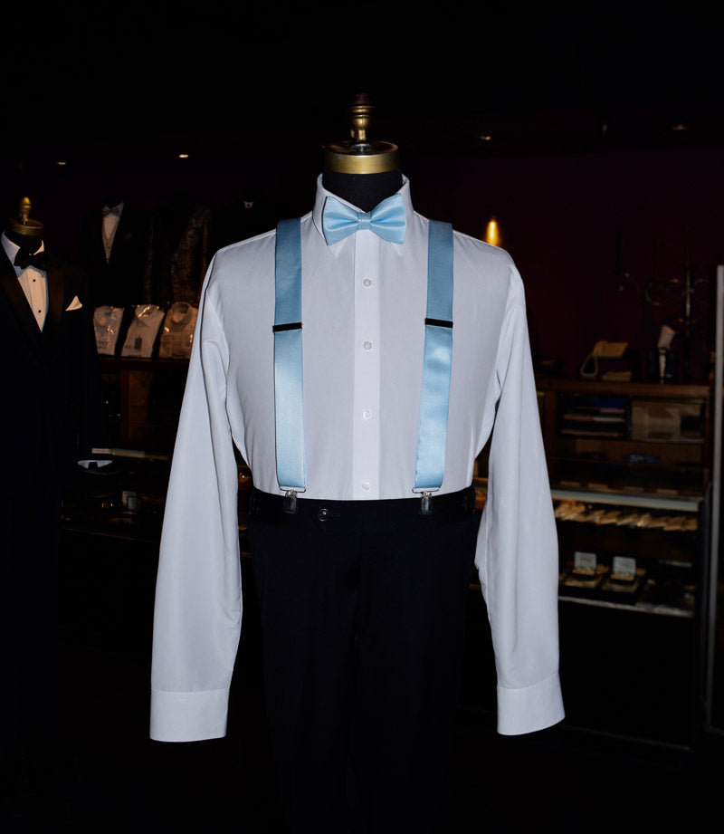 Mannequin wearing a white dress shirt with capri-blue satin suspenders and a capri-blue satin blue bow-tie in a tuxedo shop.