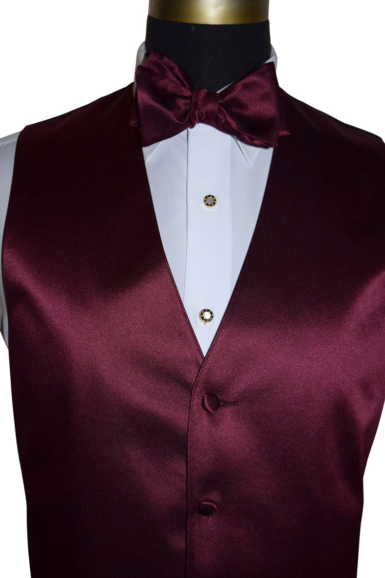 close-up mannequin wearing a white tuxedo shirt with a wine tuxedo vest and wine bowtie against a white background