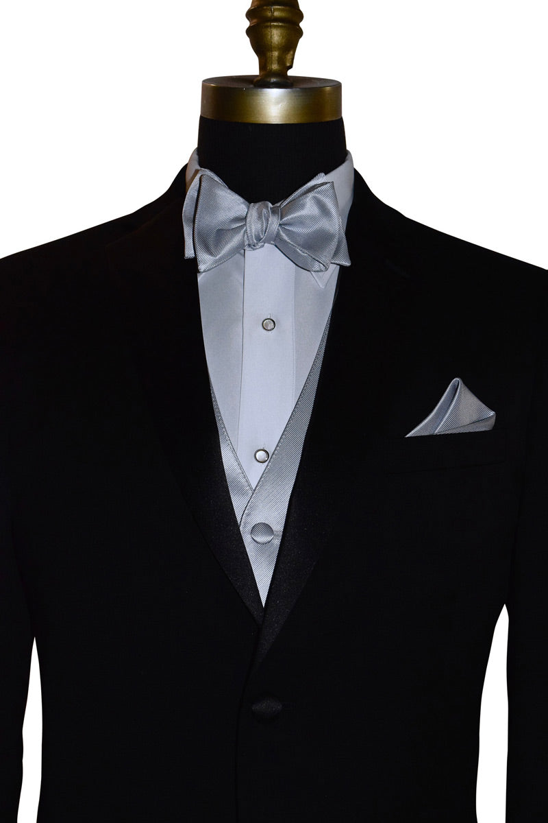 Black tuxedo with silver bow tie and silver vest and pocket square on a mannequin against a white background