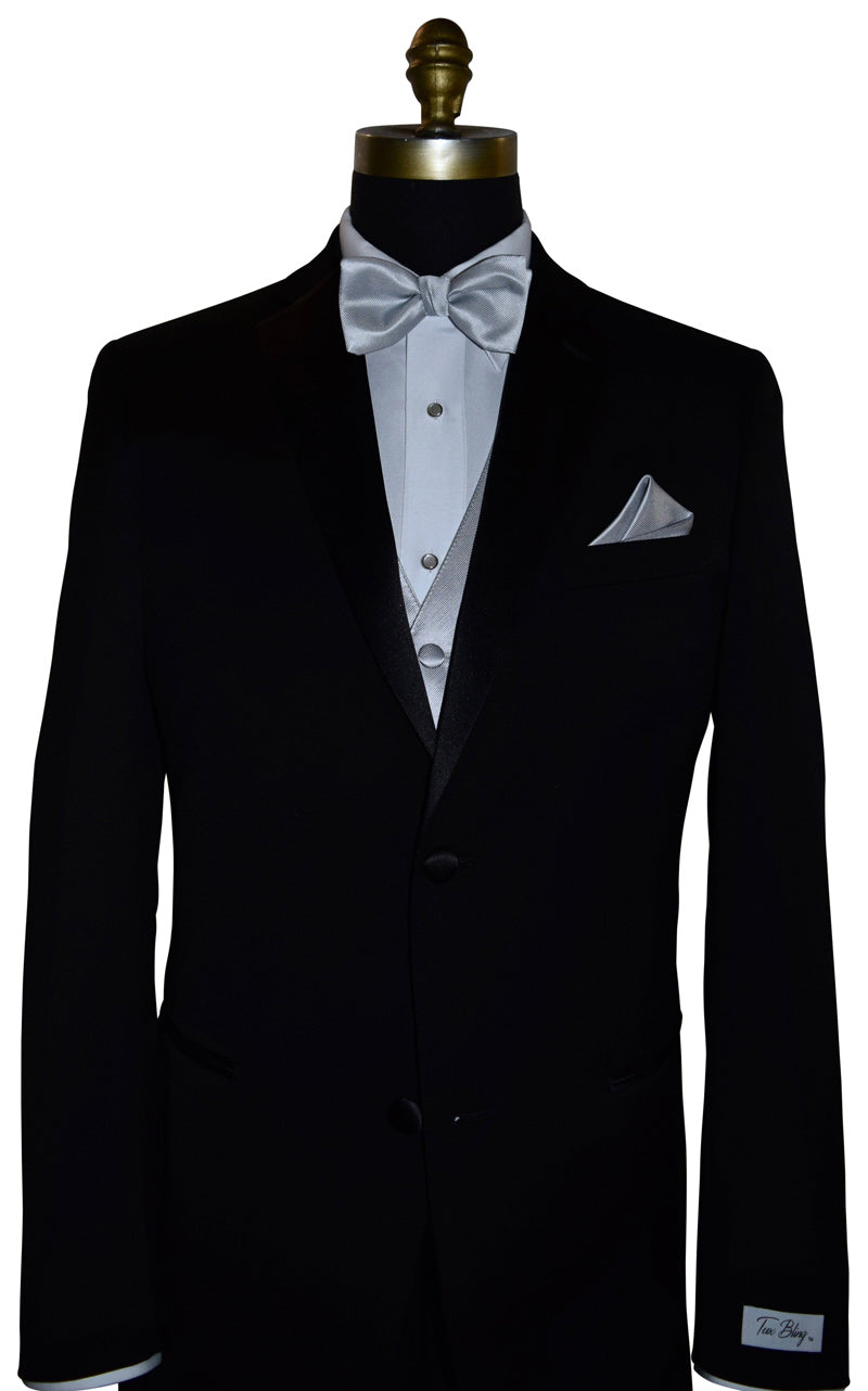 Black tuxedo with white shirt, silver vest and bow tie, and pocket square on a mannequin.