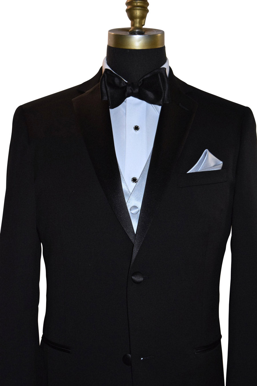 Black tuxedo with white shirt and silver tuxedo vest with a black satin bow tie on a mannequin against a white background