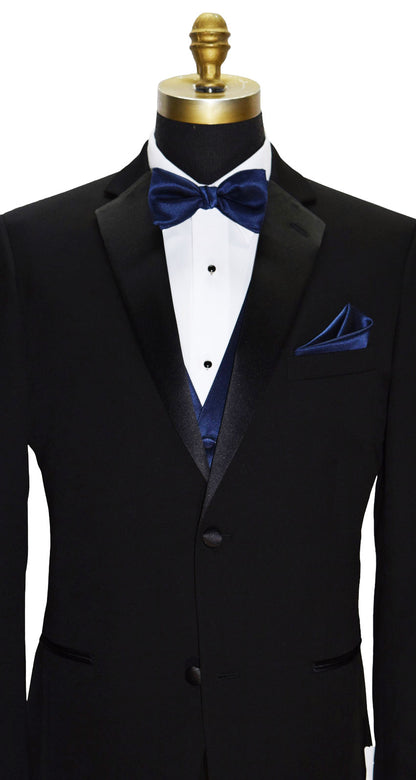 close-up black notch lapel tuxedo with a white tuxedo shirt and a marine-blue bowtie and marine-blue vest and pocket handkerchief against a white background