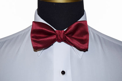 apple colored bow tie on a white shirt with black lapels