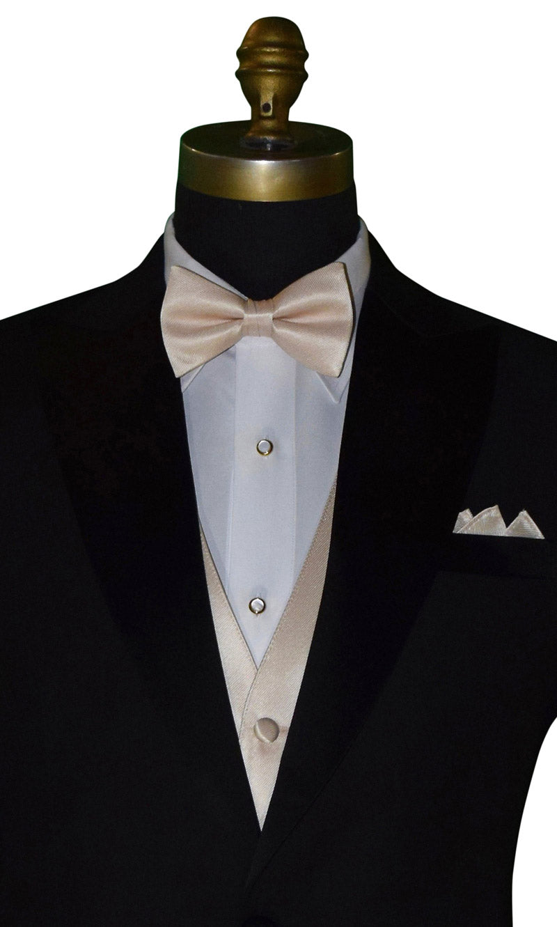very close up, black tuxedo with a white shirt and champagne tuxedo vest and bowtie against a white background