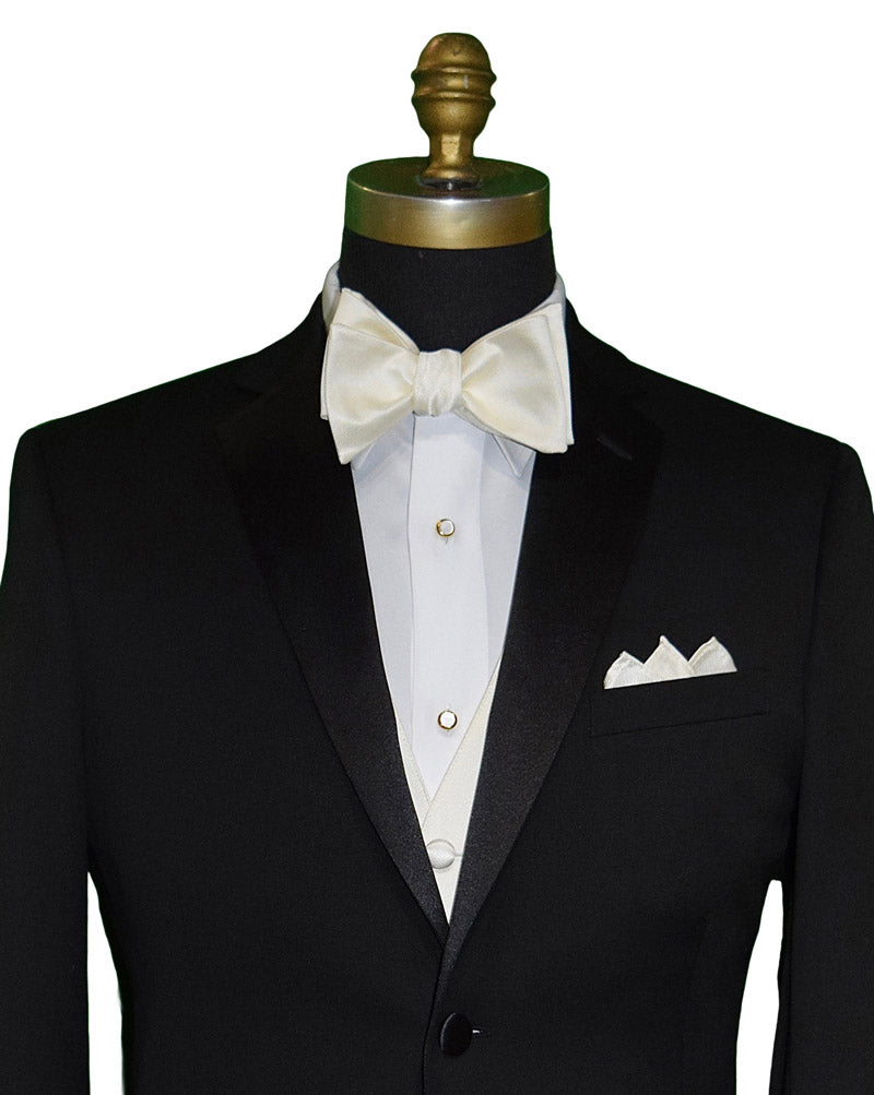 Close up of a black notch lapel tuxedo shown with a off-white "tie yourself" bowtie and off-white vest and pocket handkerchief