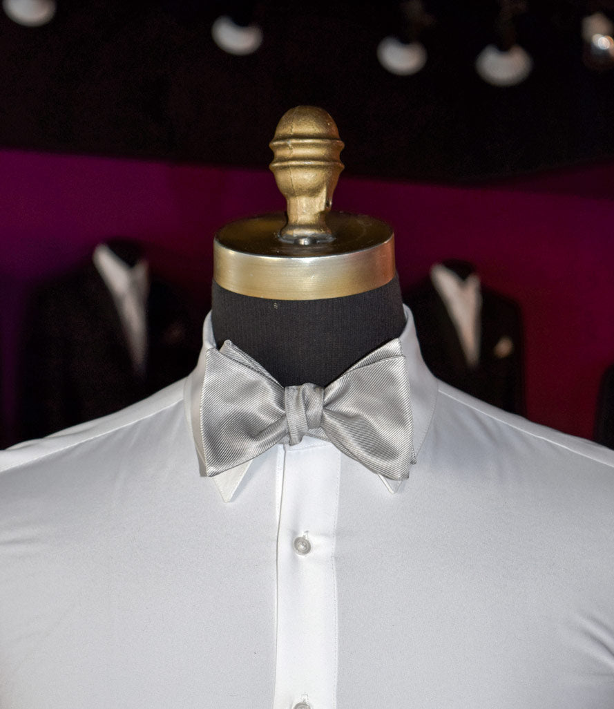 White dress shirt with a moonlight-gray "tie-yourself" bow tie on a mannequin against a dark background