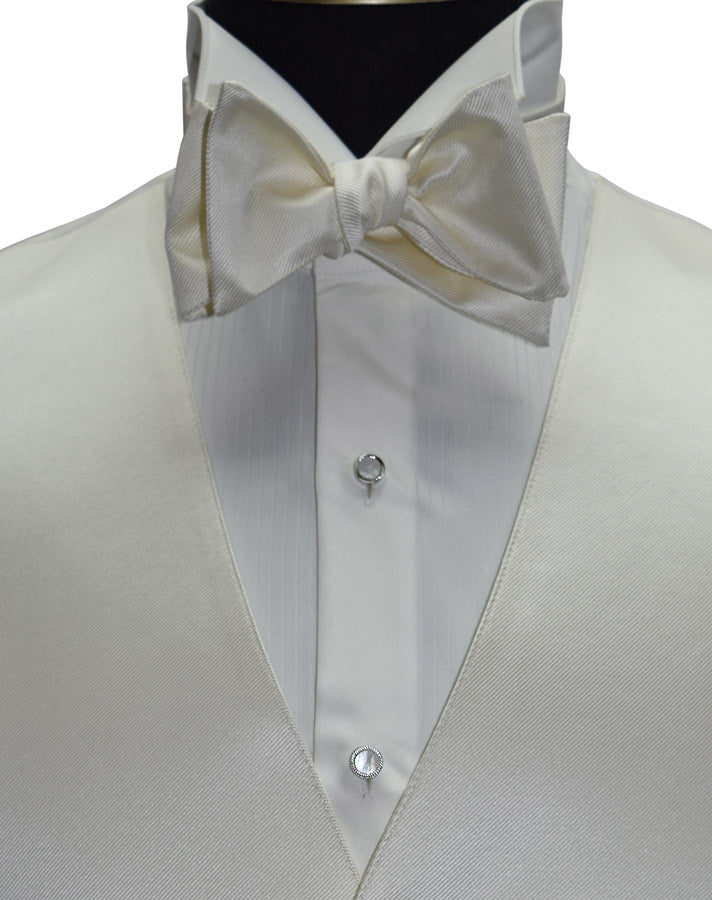 close-up off-white tuxedo vest and off-white "tie-yourself" bowtie on a ivory tuxedo shirt against a white background