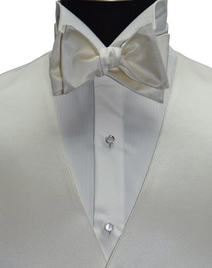 close-up off-white tuxedo vest and off-white "tie-yourself" bowtie on a ivory tuxedo shirt against a white background