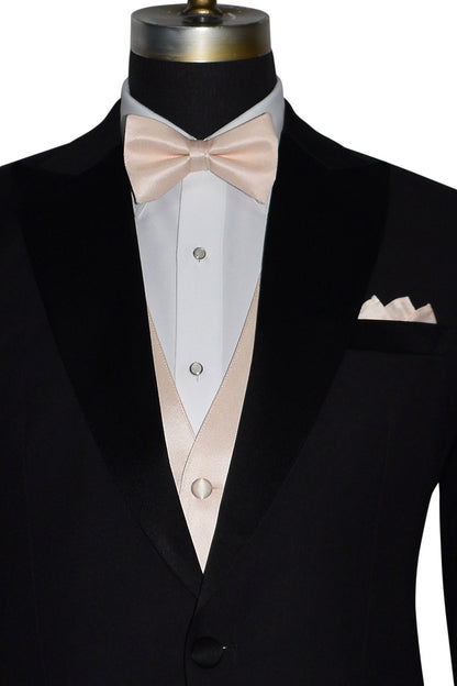 very close black tuxedo wearing a nude "pre-tied" bowtie and nude vest against a white background