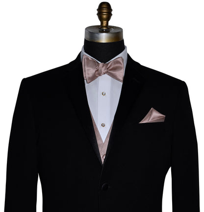 close-up black notch-lapel tuxedo with a white dress shirt and a rose-gold tuxedo vest and rose-gold "tie-yourself" bowtie and pocket handkerchief against a white background