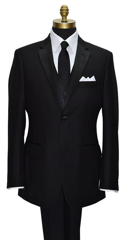 close-up black notch lapel tuxedo with a white tuxedo shirt and a long black necktie and a four-button black tuxedo vest against a white background