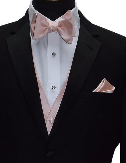very close up Black tuxedo with blush "tie-yourself" bow tie and pocket square and vest on a mannequin against a white background
