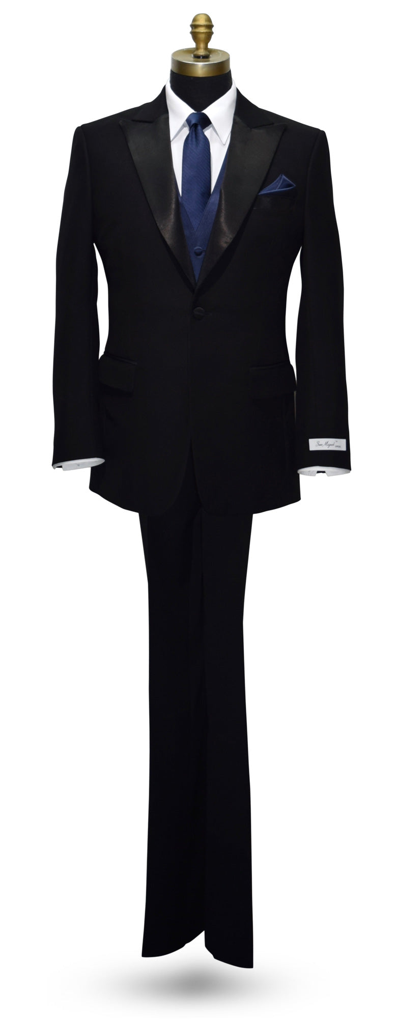 life-size mannequin wearing a "San Miguel Especial" black peak lapel tuxedo with a marine blue striped necktie and a marine blue tuxedo vest against a white background