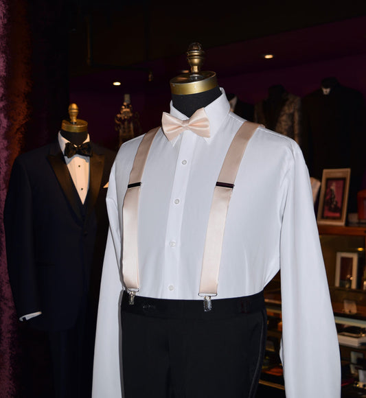 side view mannequin wearing a white shirt with nude satin suspenders and nude bowtie from tuxclub inside a tuxedo shop
