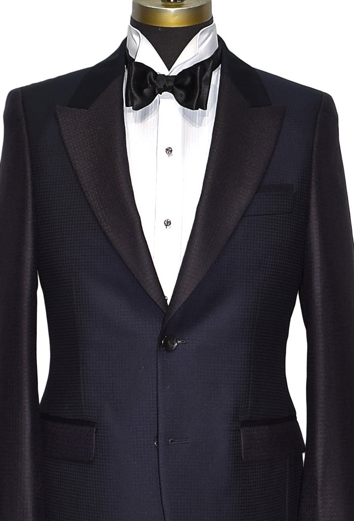 very close navy-blue peak lapel tuxedo with white wing collar tuxedo shirt and "tie-yourself" black bow tie on a mannequin against a white background