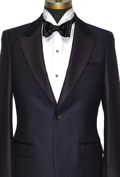 very close navy-blue peak lapel tuxedo with white wing collar tuxedo shirt and "tie-yourself" black bow tie on a mannequin against a white background