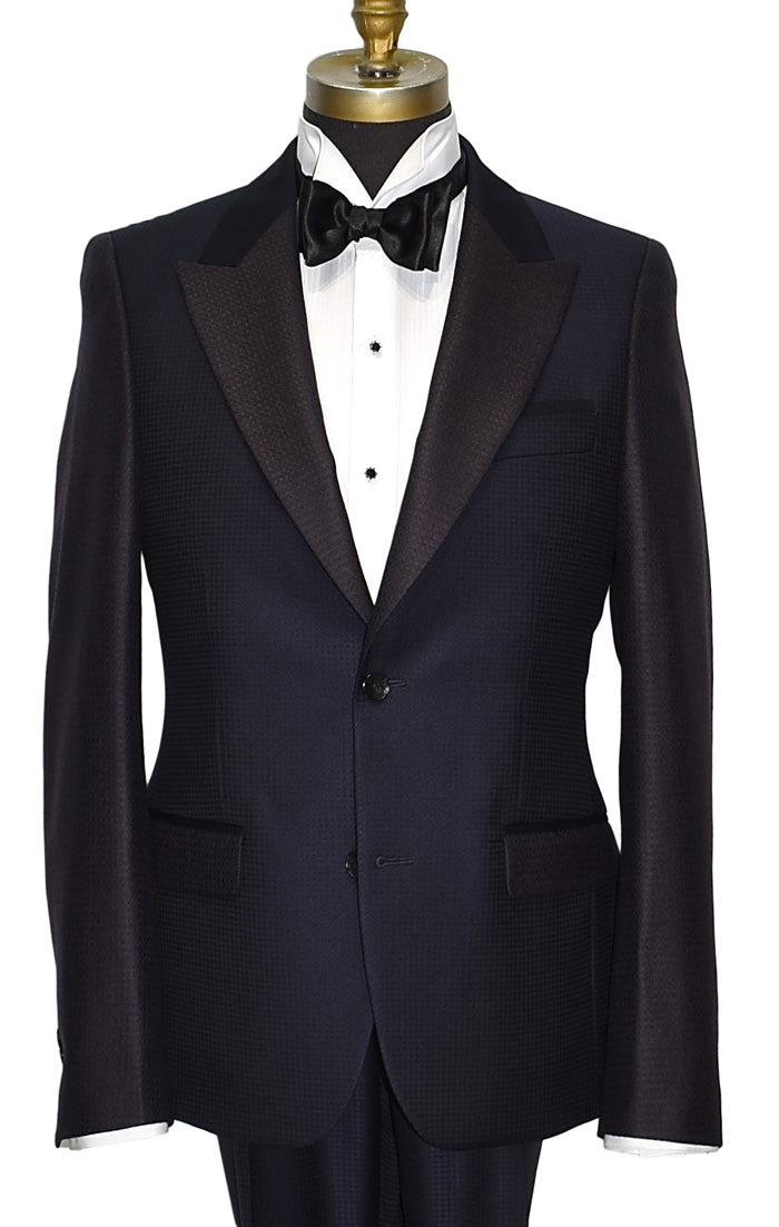 close-up navy-blue peak lapel tuxedo with white shirt and black bow tie on a mannequin against a white background
