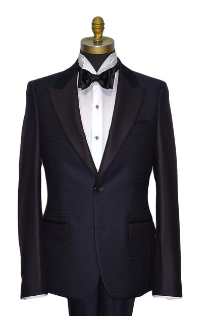 navy blue peak lapel tuxedo on a mannequin with a white tuxedo shirt and a black satin bowtie with studs and cufflinks on the tuxedo shirt