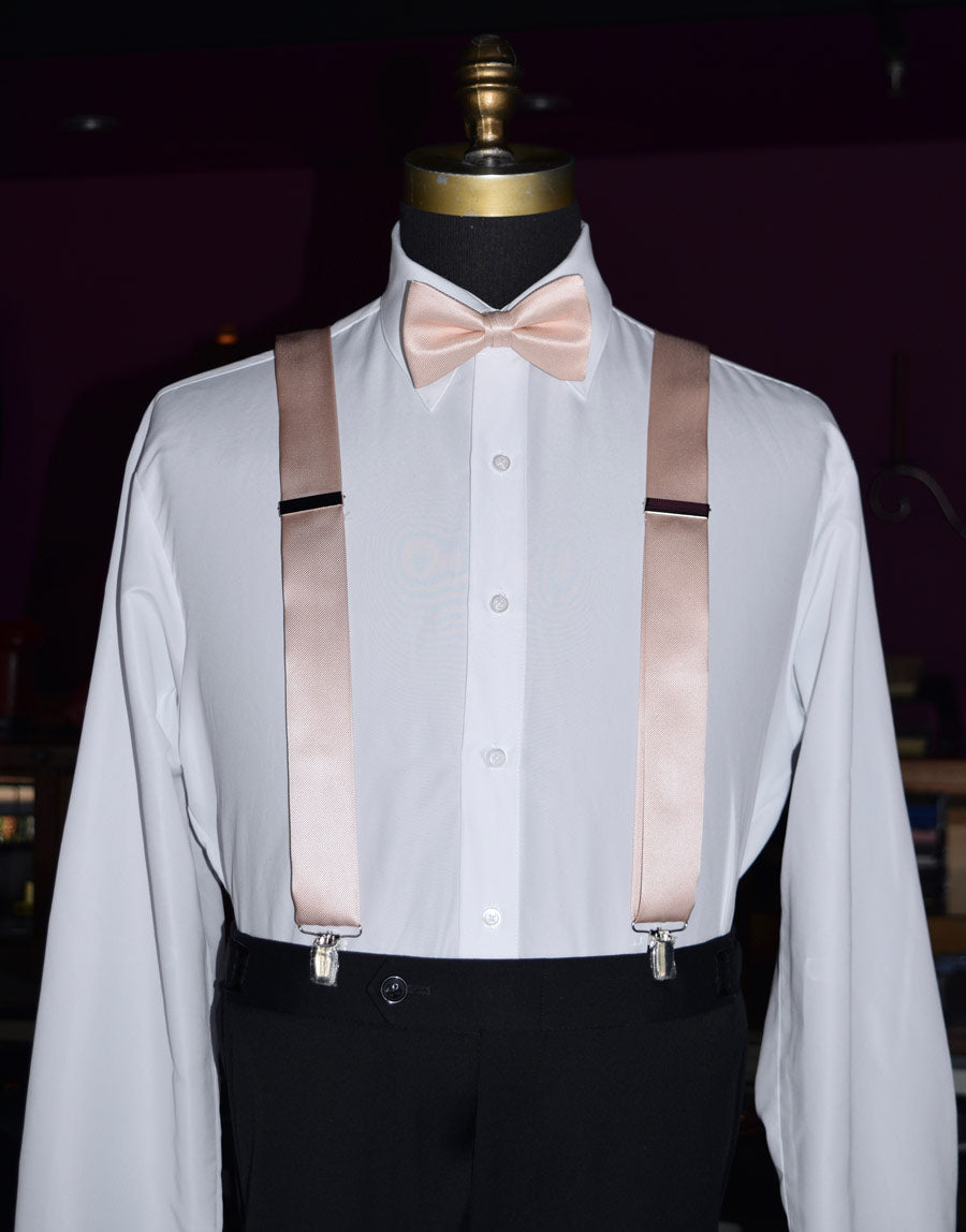 Mannequin wearing a white dress shirt with petal satin suspenders and a petal bow tie against a dark background