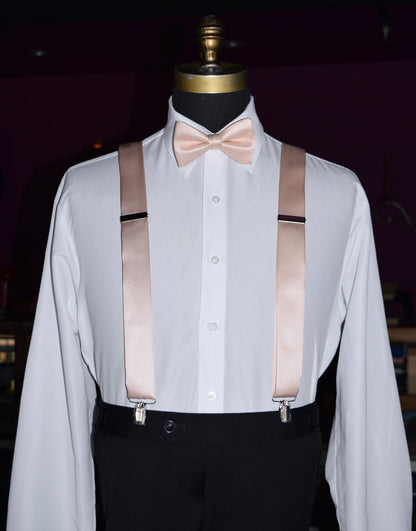 Mannequin wearing a white dress shirt with petal satin suspenders and a petal bow tie against a dark background