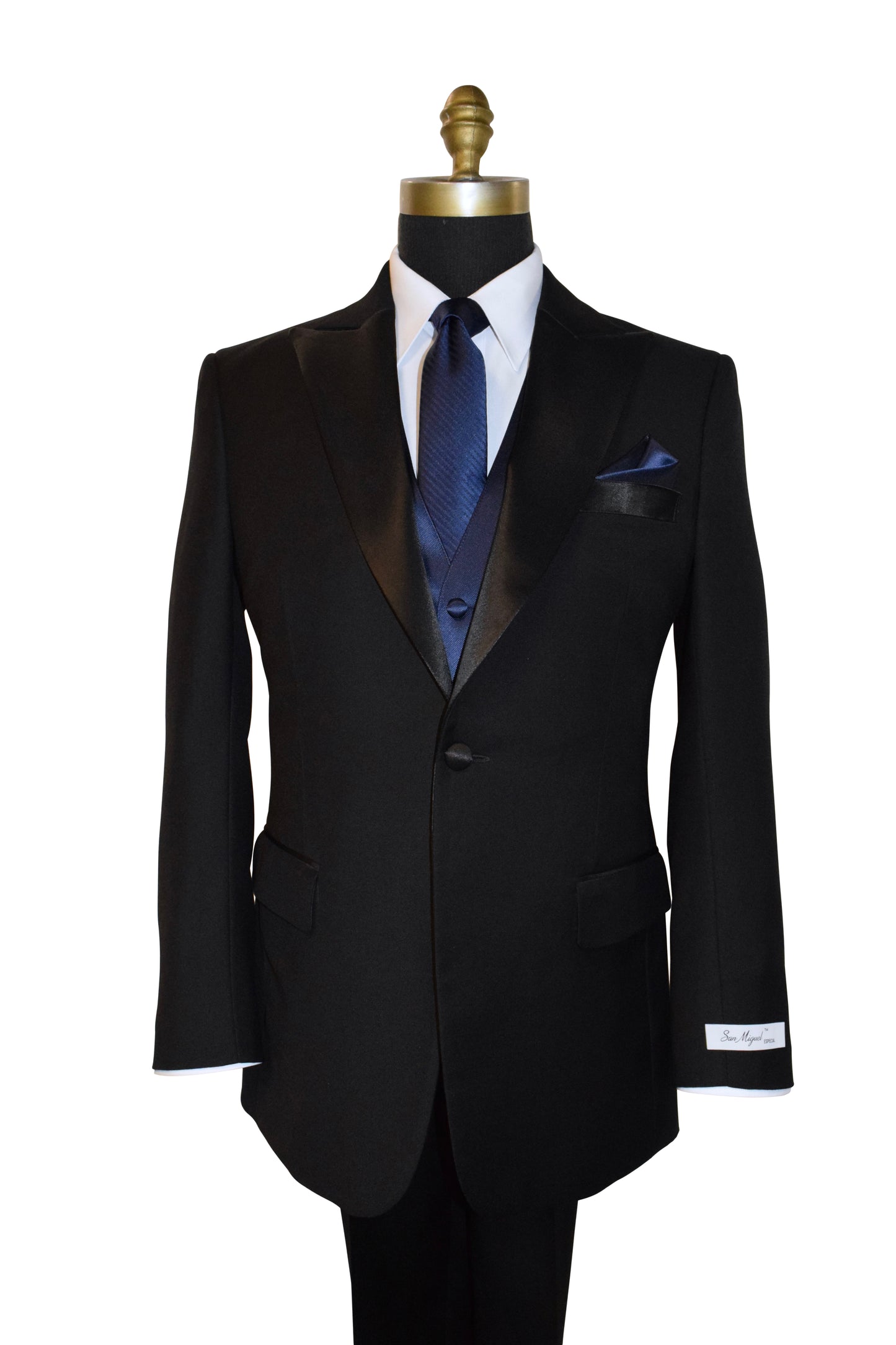 Black peak lapel tuxedo with a blue necktie tie and vest on a mannequin against a white background
