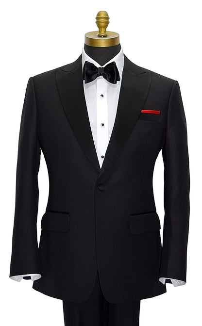 Black peak lapel tuxedo with a black bowtie and a red pocket handkerchief on a mannequin against a white background