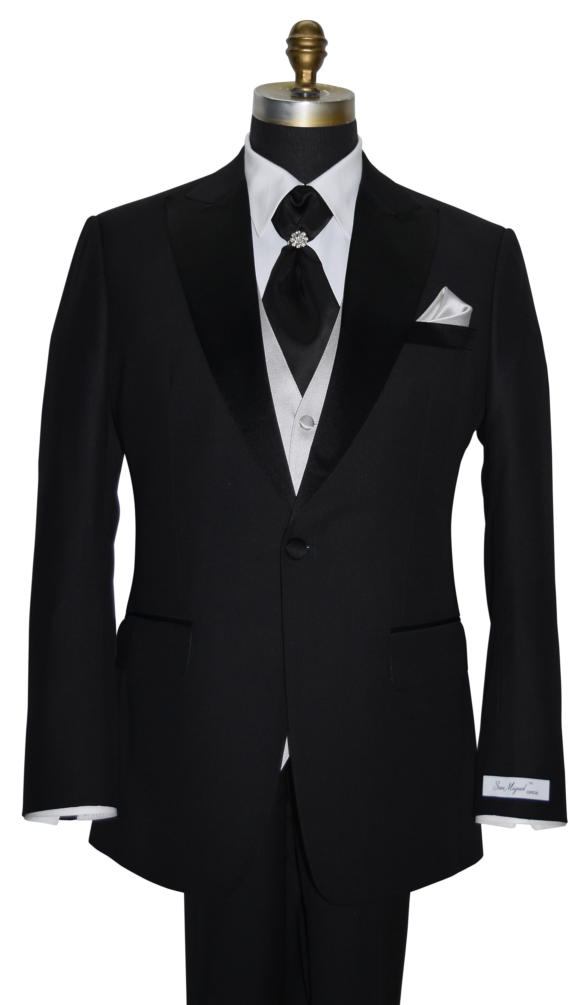Black peak lapel tuxedo with white shirt and black cravat and gray vest on a mannequin against a white background