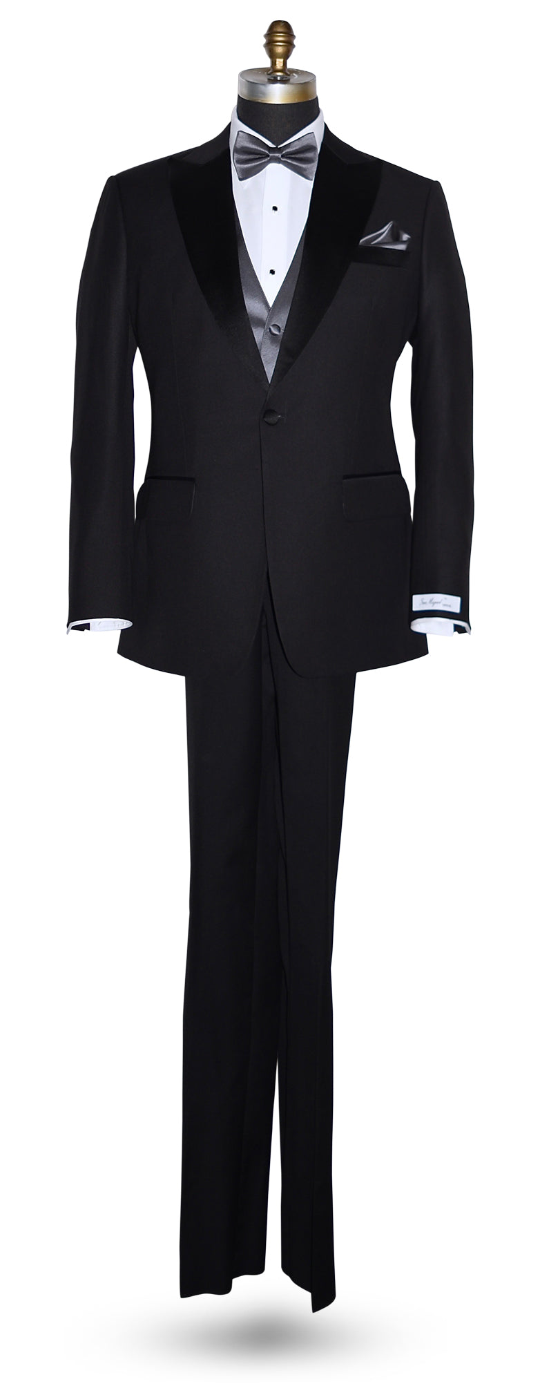 Black peak lapel tuxedo  tuxedo on a mannequin wearing a charcoal bowtie and charcoal vest against a white background