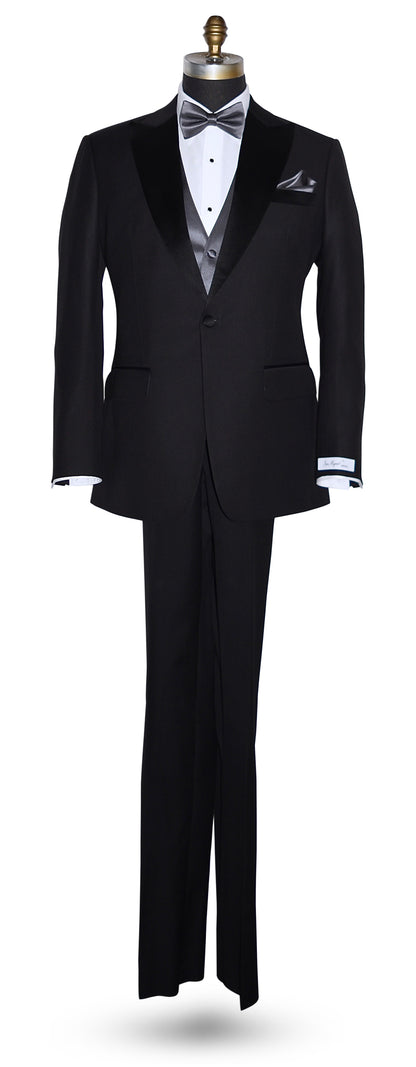 Black peak lapel tuxedo  tuxedo on a mannequin wearing a charcoal bowtie and charcoal vest against a white background
