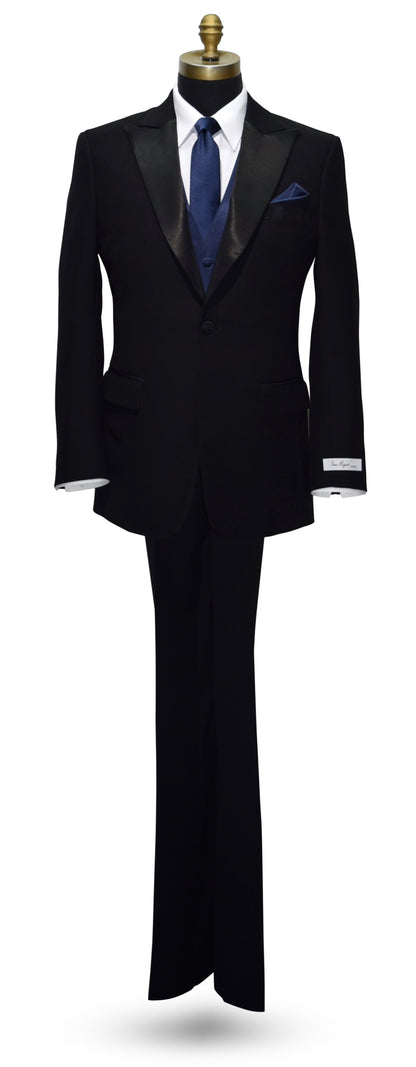 Black peak lapel tuxedo with a blue necktie and blue vest on a white background
