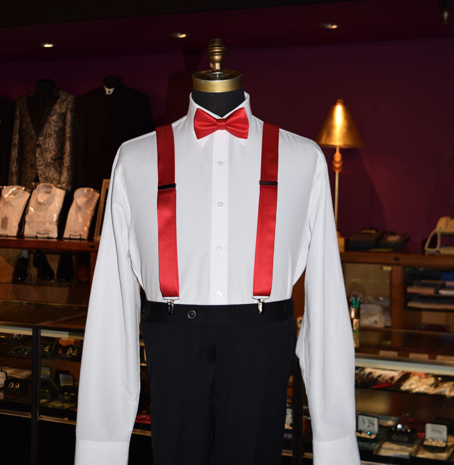 Mannequin wearing a white dress shirt with red satin suspenders and bow tie in a a  men's store